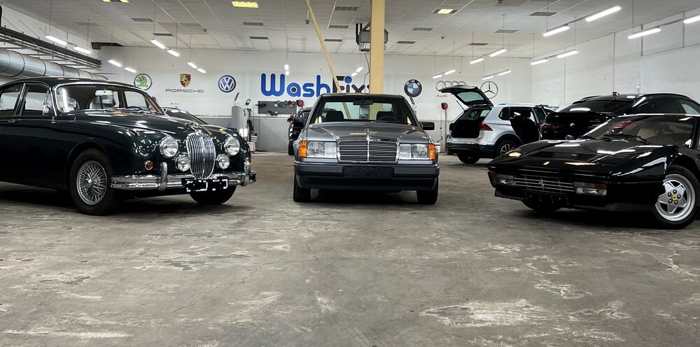 Jaguar MK2, Mercedes W124 und Ferrari 328 GTS nebeneinander in der WashFixx Aufbereitungshalle